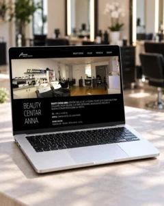 Web stranica Beauty Centra Anna prikazana na laptopu s interijerom frizerskog salona u pozadini.