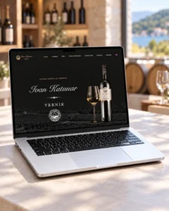 Web stranica Kuće vina Ivan Katunar prikazana na laptopu s vinskom kušaonicom u pozadini.